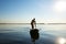 Joyful guy paddling on a SUP board