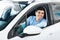 Joyful Guy Sitting In New Car Driving From Dealership Shop