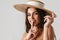 Joyful half-naked girl in straw hat showing silence gesture