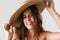 Joyful half-naked girl in straw hat smiling and looking at camera