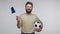 Joyful happy football fan bearded guy in t-shirt holding soccer ball and waving European Union flag, excited about win