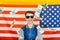 Joyful and happy guy in sunglasses on the background of the American flag, dollars are falling from above, the concept of