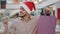 Joyful hispanic guy in Santa hat stand in mall holding money and gift bags looking at camera male shopper happily