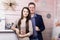 Joyful husband and wife posing by the decorative fireplace. Festive clothes and decorations