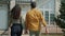 Joyful husband and wife walking to new house front door talking smiling outdoors