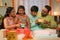 Joyful Indian parents giving diwali surprise gifts to sibling Kids at home - concept of festival celebration