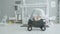 Joyful infant girl sitting in baby car at home