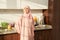 Joyful Islamic woman standing near kitchen counter at home