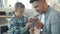 Joyful kid having fun with guitar while caring dad creative man teaching him to play music