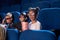 Joyful kids watching movie in 3D glasses, in cinema.