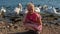 Joyful lady in a beautiful dress, an adult with a kind look on the background of swans on the lake on a summer day