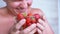 Joyful laughing Male Sniffing Smelling Strawberry with his Nose in Room. 4K