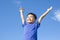 Joyful little boy holding a toy with blue sky