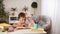 Joyful little boy sitting at the table with pencils and textbooks. Happy child pupil doing homework at the table