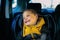 A joyful little boy smiles in a child`s car seat. Child safety when driving