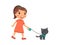 A joyful little girl is holding a cute black kitten on a harness.