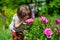 Joyful little girl sniff flowers