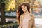 Joyful long-haired ginger girl in elegant hat spending leisure time, exploring city in autumn day. Outdoor photo of