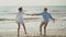 joyful lovely Couple Having Fun Running Along sandy Beach Together