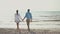 joyful lovely Couple Having Fun walking Along sandy Beach Together