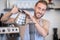 Joyful male barista with teapot pouring water