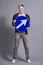 Joyful man holding round blue sign with arrow.