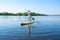 Joyful man paddling on a SUP board on large river