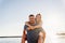 joyful man and woman in love hugging and having fun on sea beach. solar glare