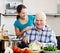 Joyful mature couple cooking food