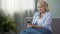 Joyful mature woman scrolling news in social media on smartphone at home, app