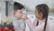 Joyful Middle Eastern brother and sister having fun in kitchen touching noses and laughing. Portrait of cheerful