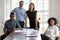 Joyful millennial diverse professionals gathered near table.