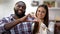 Joyful mixed-race couple showing heart sign made with hands at camera, love