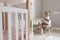 Joyful mixed race toddler girl playing at nursery sitting by the kids furniture