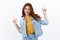 Joyful modern sassy redhead girl with freckles in denim jacket, dancing happily, shopping online show links, pointing up