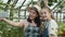 Joyful mother and child taking selfie with smartphone posing in greenhouse