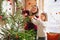 Joyful mother and lovely girl in knitted sweaters decorating x-mas fir-tree with new year baubles