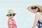 Joyful mother and son in hats and sunglasses. Sky on background