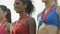 Joyful multiracial girls standing on podium, proudly showing medals on chests