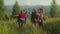 Joyful multiracial hikers celebrating successful mountain hiking and giving high five at sunset