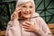 Joyful old lady talking on cell phone outdoors stock photo