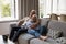 Joyful older couple relax on sofa laughing watching comedy movie