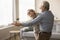 Joyful older retired husband and wife dancing to music