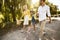 Joyful Parents And Daughter Holding Hands Walking Outside In Countryside