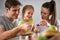 Joyful parents playing together with their daughter