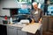 Joyful pizzeria worker makes a pizza box. Catering kitchen work.