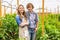 Joyful plant growers posing for the camera in a greenhouse