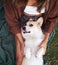 Joyful playtime, young woman cuddles with a smiling Welsh Corgi in the park