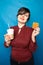 Joyful plus size woman with short hair in business clothes resting and drinking coffee with a straw with Viennese waffle