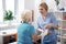 Joyful positive nurse wrapping bandage around her patients hand